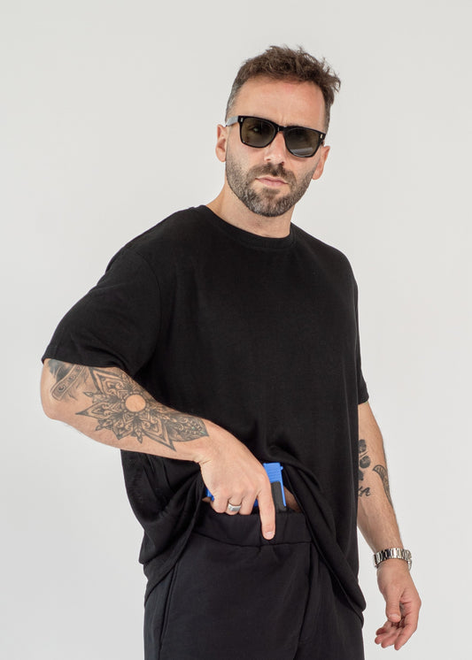 Man wearing a black outfit with sunglasses on a white background